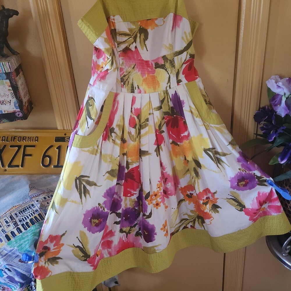 Delightful floral flowing dress with nice accenting on neckline, hem & pockets